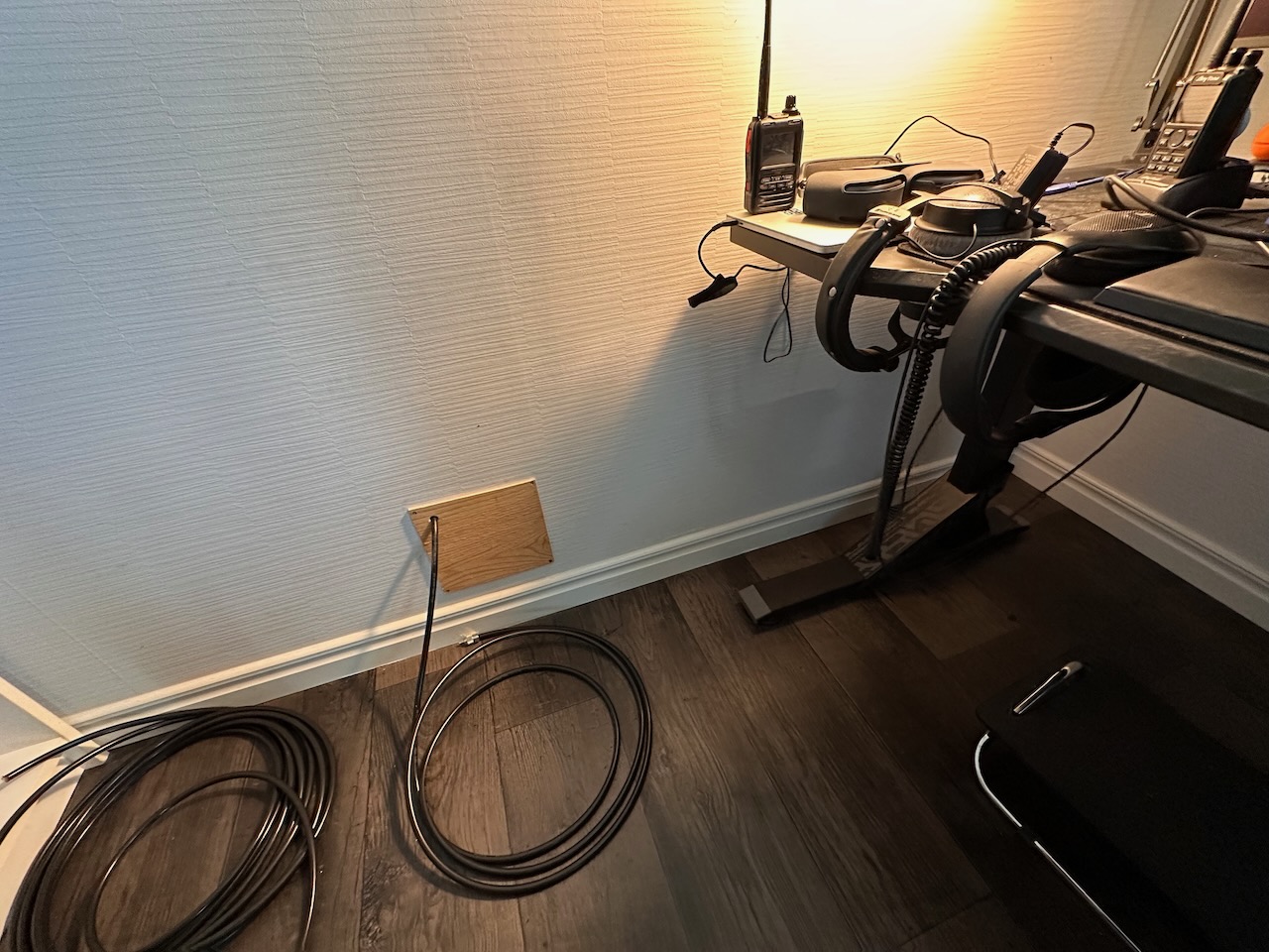 Cable passing through old cat door, now covered with wood. Hole drilled for coax.